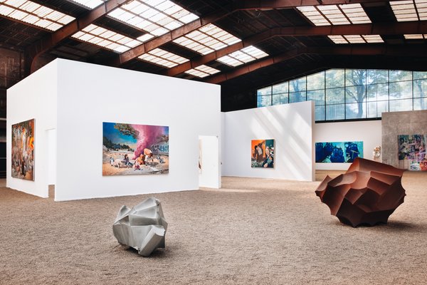 Kunst & Kultur (© Rainer Binz) Eine Kunstaustellung in einer Industriehalle. Gemälde hängen an der Wand.