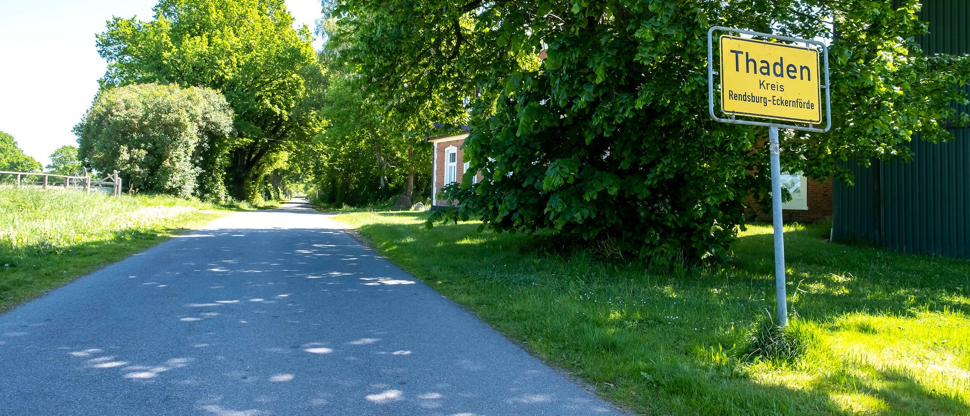 Das Ortsschild der Gemeinde Thaden im Amt Mittelholstein am Straßenrand