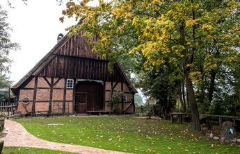 (© MHT.SH & Peter Lühr) Historisches Fachwerk-Haus mit Reetdach steht im Grünen in Aukrug.
