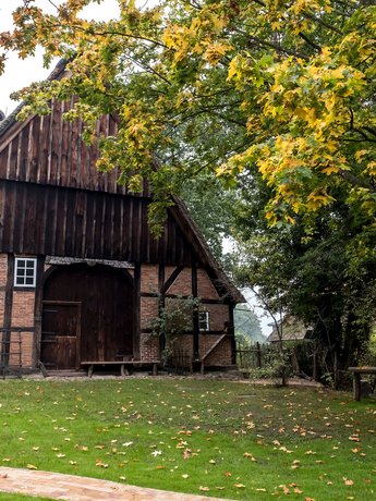 (© MHT.SH & Peter Lühr) Historisches Fachwerk-Haus mit Reetdach steht im Grünen in Aukrug.