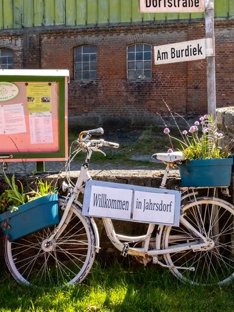 Jahrsdorf (© mht.sh | Peter Lühr) Fahrrad mit einem WIllkommen-Schild in Jahrsdorf