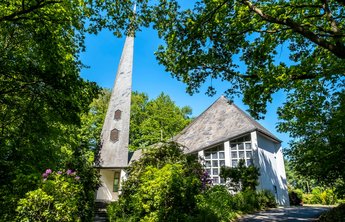 Kunst & Kultur (© mht.sh | Peter Lühr) Weiße St. Johanneskirche unter grünen Bäumen in Gokels im Amt Mittelholstein