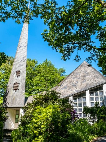 Weiße St. Johanneskirche unter grünen Bäumen in Gokels im Amt Mittelholstein