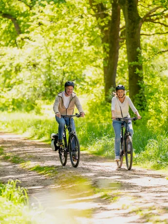 Shooting Kropper Busch - Ochsenweg (Ochsenweg - Gley Rissom Thieme ) Zwei Menschen fahren auf Rädern durch grüne idyllische Landschaft auf dem Radfernweg Ochsenweg.