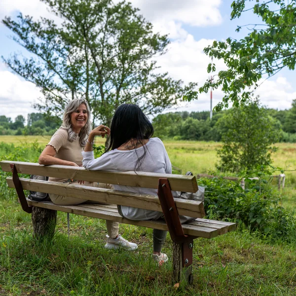 Zwei Frauen sitzen auf einer Bank im Naturpark Aukrug.