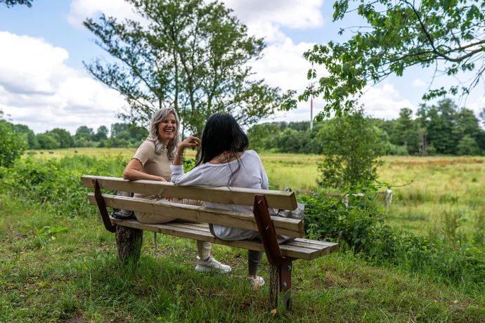 Naturpark Wanderweg (sh-tourismus.de/MOCANOX) Zwei Frauen sitzen auf einer Bank im Naturpark Aukrug.