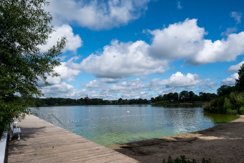 Badestelle am Bordesholmer See mit Steg und Sandstrand.