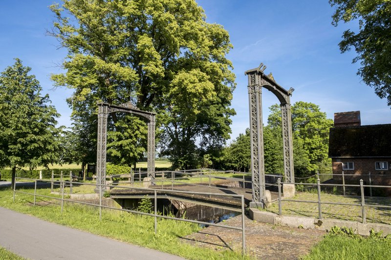 Historische Schleuse Kluvensiek in Bovenau mit grüner Umgebung und blauem Himmel.