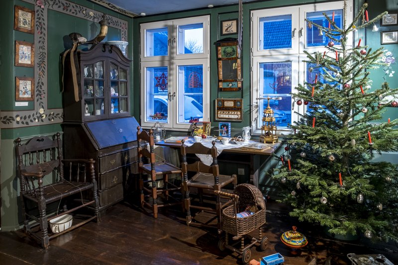 Ein traditionell eingerichtetes Zimmer mit Weihnachtsbaum, antiken Möbeln und Dekorationen im Heimatmuseum Hohenwestedt.