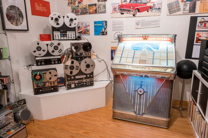 Ein Raum mit alten Tonbandgeräten und einer Wurlitzer-Jukebox.
