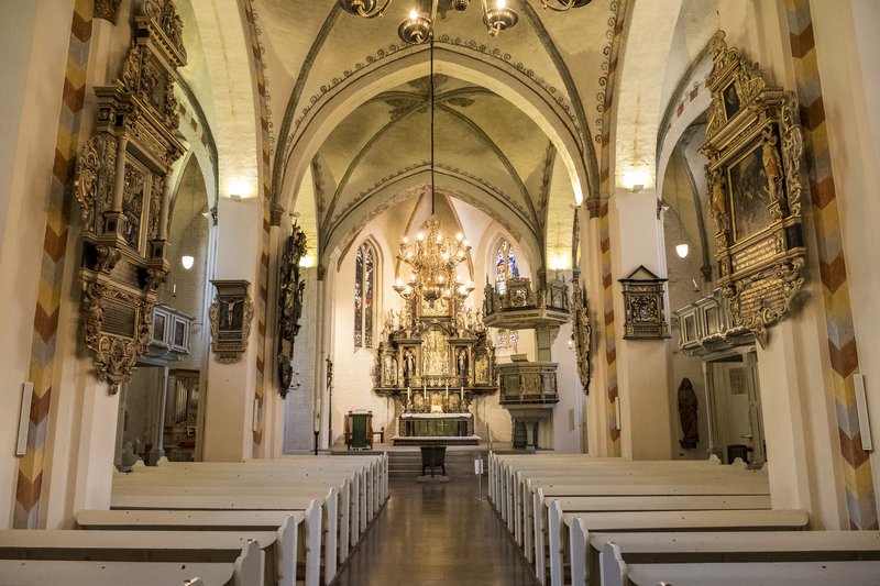 Innenansicht der St. Marien Kirche in Rendsburg mit Altar und Bänken.