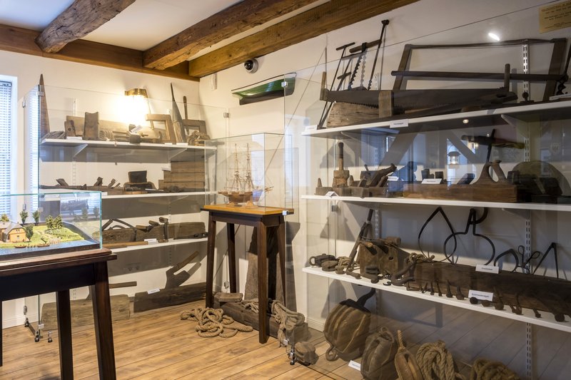Innenansicht eines Museums mit maritimen Artefakten und Schiffsmodellen.
