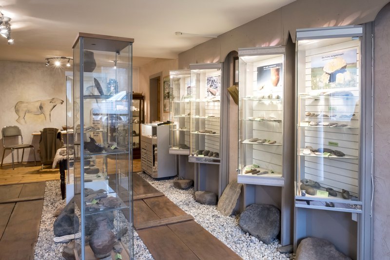 Innenansicht eines Museums mit Vitrinen voller archäologischer Artefakte.
