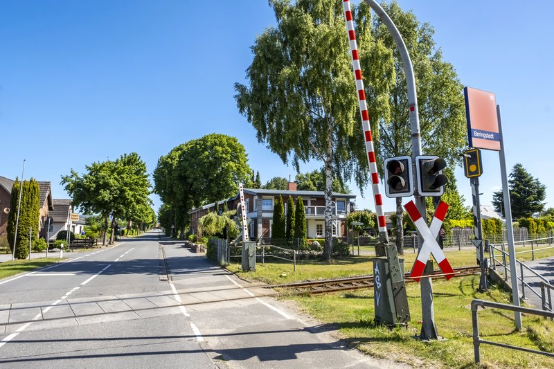 Bahnübergang mit Schranken und Bahnsignal am Bahnhof Beringstedt.