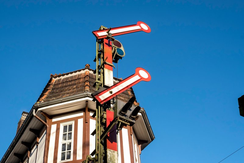 Historisches Stellwerk mit Signalen vor blauem Himmel.