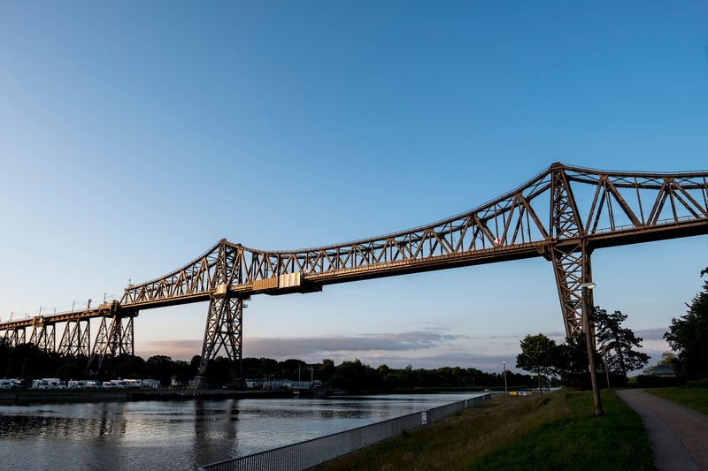 Eisenbahnhochbrücke Rendsburg über den Nord-Ostsee-Kanal bei Sonnenuntergang.